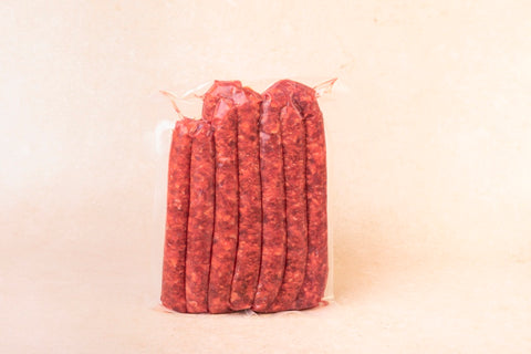 Image de merguez artisanales fraîches conditionnées sous vide, fabriquées à partir de porc béarnais dans les ateliers de la Maison Lahouratate.